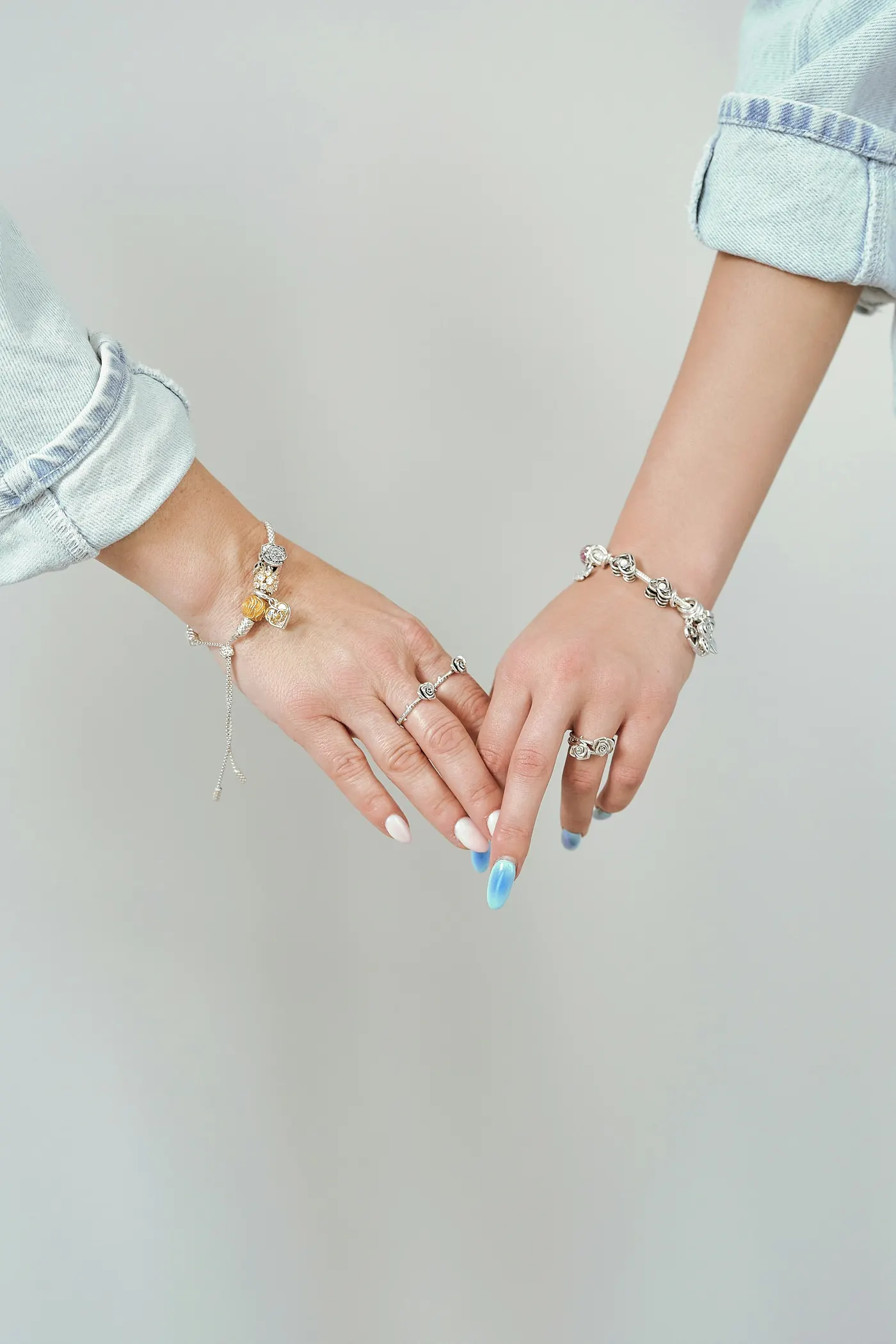 Zwei Freundinnen halten ihre Hände mit Armbändern nebeneinander
